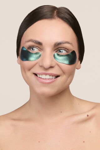 Photo d'une mannequin souriante portant nos patchs hydrogel marbrés. Des patchs innovants par leurs couleurs marbrées se rapprochant de celles de la malachite.