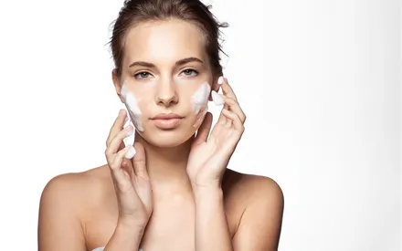 Mannequin qui utilise sur son visage la mousse nettoyante 