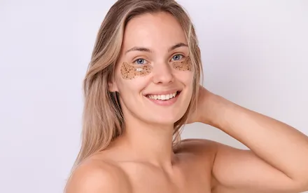 Une femme blonde sourit, portant sous les yeux les patchs hydrogel « Yeux Relaxants » qui offrent au regard tous les bienfaits d’une infusion réconfortante. Ce patch est infusé de verveine, laissant apparaître à l'œil nu de délicates incrustations de particules de feuilles.