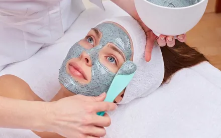  Mannequin qui se fait appliquer un masque peel-off lavande romarin avec de légères incrustations de feuilles.