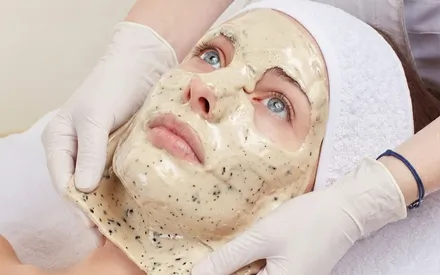 Mannequin qui se fait retirer en une seule pièce un masque peel-off beige aux éclats de feuilles d'olivier, baptisé "Masque Peel-Off Oléalgues".
