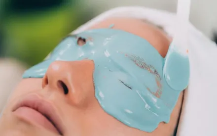 Une cliente en institut de beauté recevant un soin contour des yeux avec un masque peel-off, liquide qui gélifie.