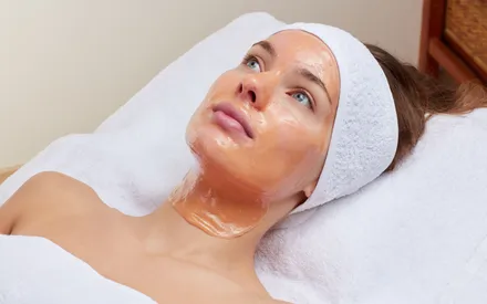 Visage d'un mannequin arborant le masque peel-off effet feuille d'or sur son visage. Ses paillettes aux reflets dorés apportent une touche de glamour et d'élégance ultime.