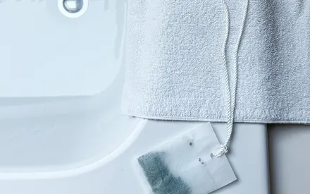 Une infusion de bain posée sur le coin de la baignoire, prête à être utilisée. Ressemblant à un gros sachet de thé, l'infusion parfumée détox pour le bain allie bien-être et action détox.