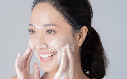 Femme en train de s'appliquer la crème nettoyante thé vert 
