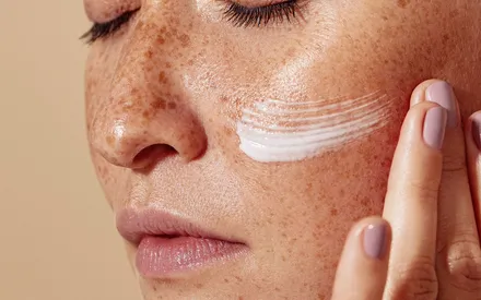 Femme qui applique sur son visage la crème douceur de crème 
