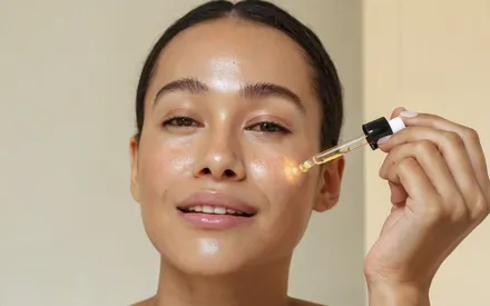 Femme en train de s'appliquer sur la visage l'huile visage 